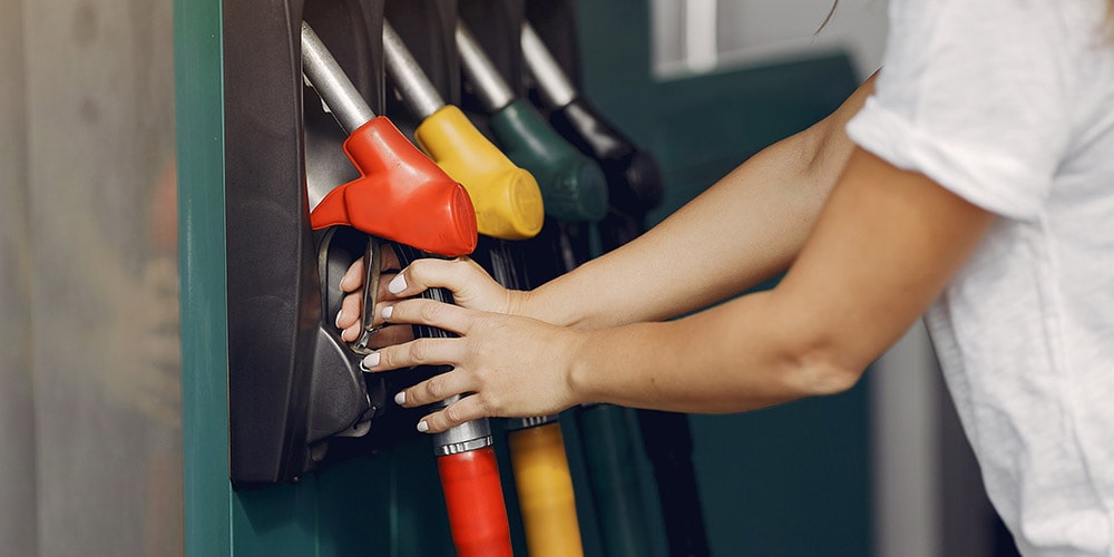 mulher-segurando-cabo-vermelho-de-combustível-para-abastecer-veículo-com-gasolina-na-reserva