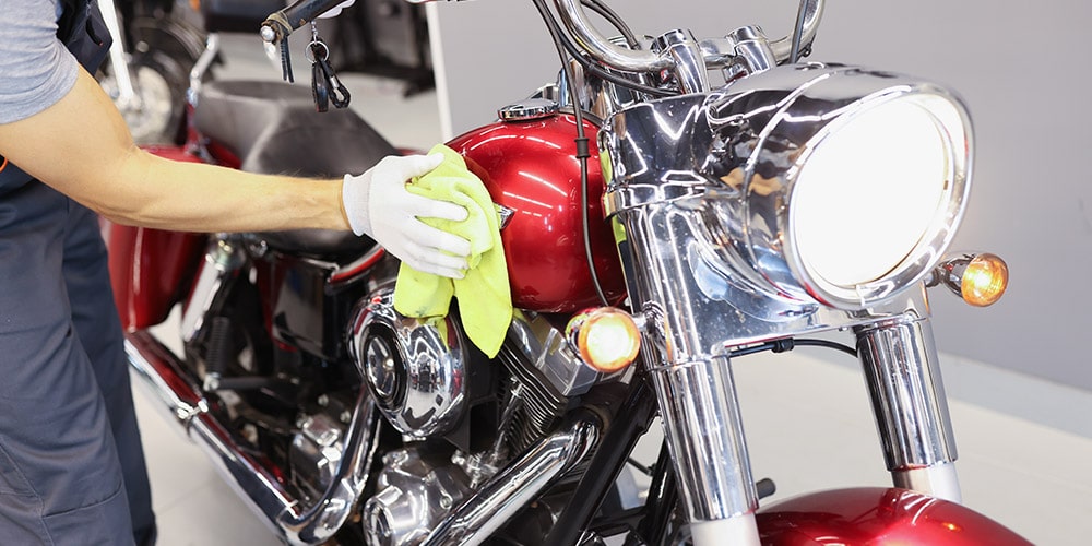 motocicleta-vermelha-sendo-polida-com-flanela-verde