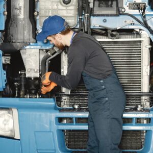 mecânico-realizando-manutenção-em-frente-de-caminhão-azul